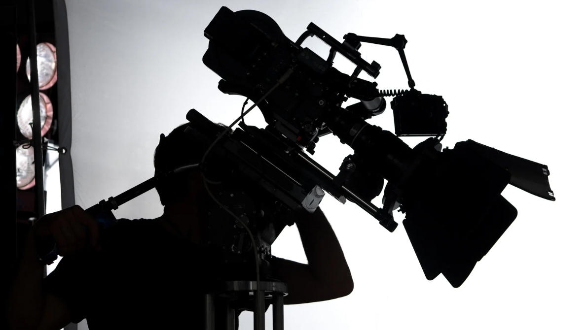 A cinematographer filming with a professional camera